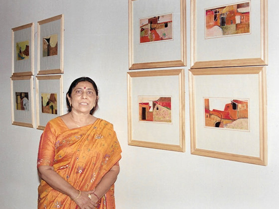 Photograph of Rekha Bhatnagar beside her paintings at Rajputana Palace Sheraton, Jaipur